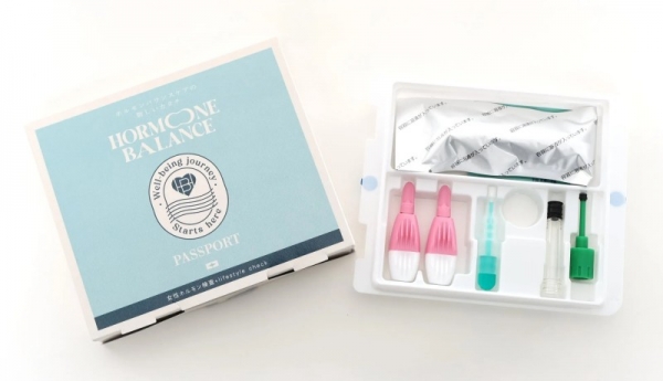 ホルモンバランスケア製品のパッケージが写っています。パッケージには「HORMONE BALANCE」の文字とロゴ、そして検査キットが入ったプラスチックケースが写っています。
