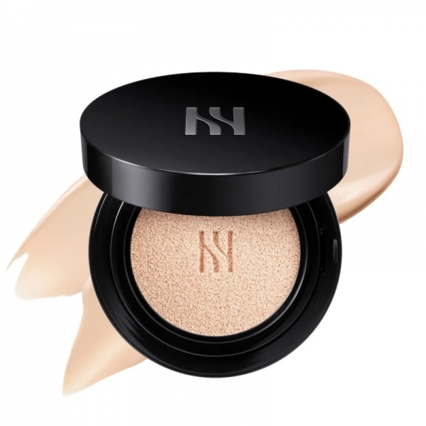 黒いケースに入ったファンデーションのクローズアップ写真。ファンデーションは開いており、パフが見え、ファンデーションのテクスチャが背景に広がっています。