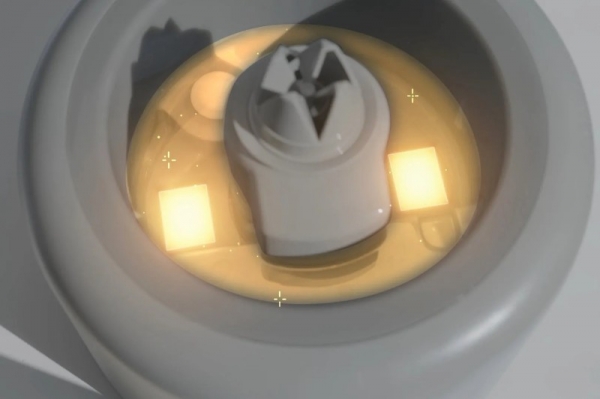 白くて丸い容器の中に、黄色く光る液体と白いパーツが配置されたイラストです。容器の形状と光の表現から、何らかの洗浄装置やデバイスの一部と推測されます。