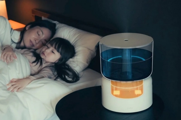 母親と子供が一緒に寝ている様子と、加湿器が置かれている様子が写った写真です。